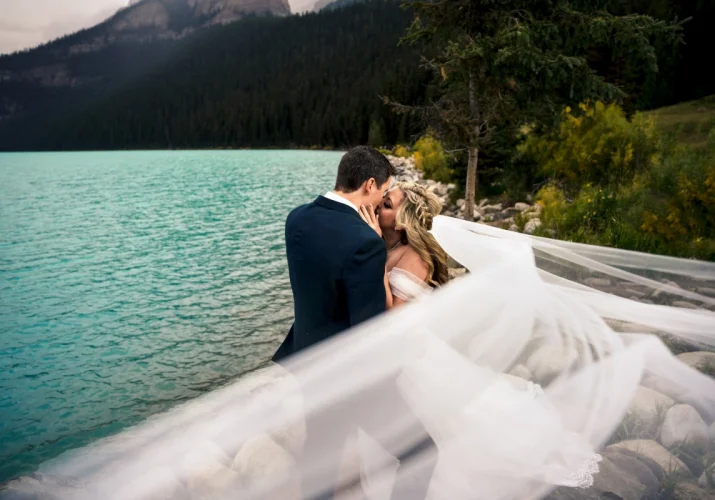 Newlyweds kiss under the veil.