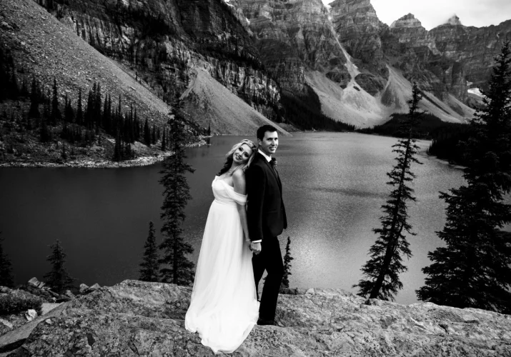 Moraine Lake wedding portrait in black and white. Newlyweds look at the Banff Wedding Photographer camera and smiles.