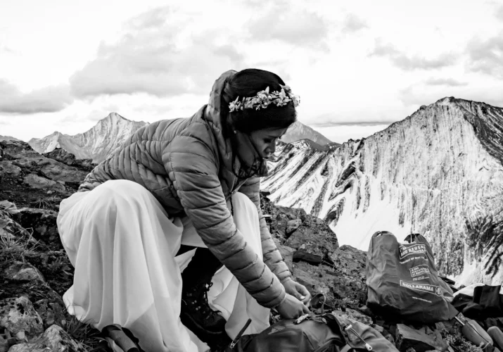 Bride is getting ready for wedding session in the mountains.