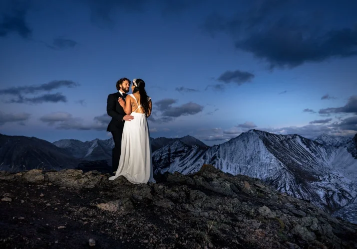 Bride and groom look at each other surrounded by the Canadian Rockies.