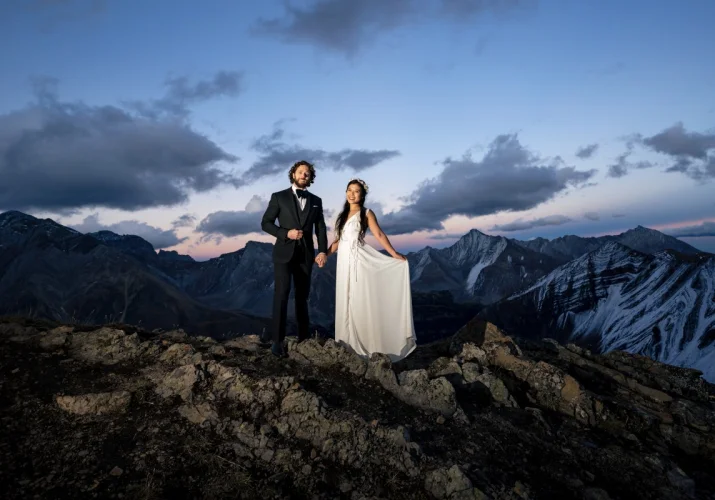 Newlyweds celebrate their love by reaching the peak of the mountain in Banff. Banff Wedding Mountain Photography.