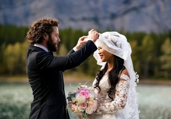 Groom lifting the bride's veil.