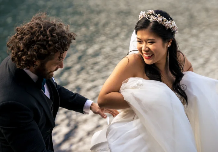 bride is lifting her wedding dress and lough to her husband