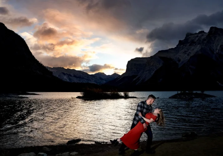 Engaged couple dancing during colourful sunrise in Banff National Park