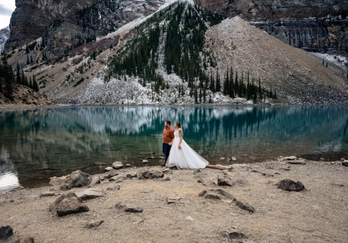 Bride and Groom walk down the blue Moraine Lake.