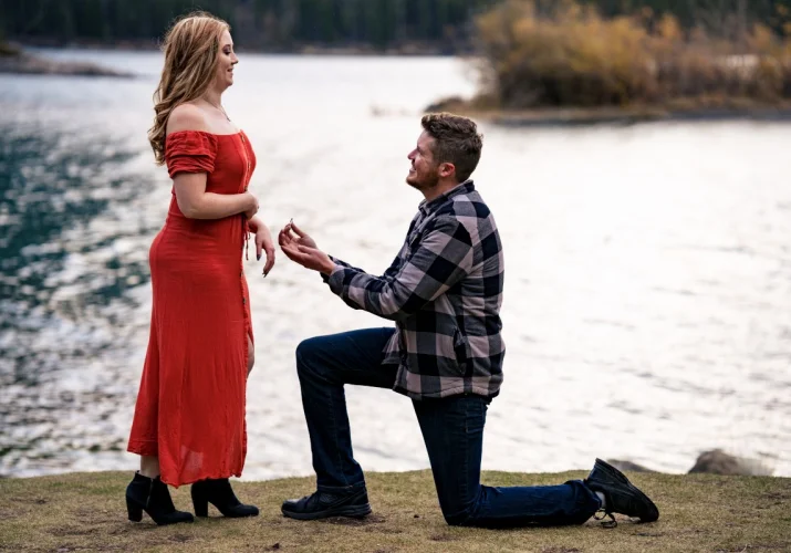 Handsome mad went down on his knee and propose his girlfriend. at Minnewanka Lake in Banff.