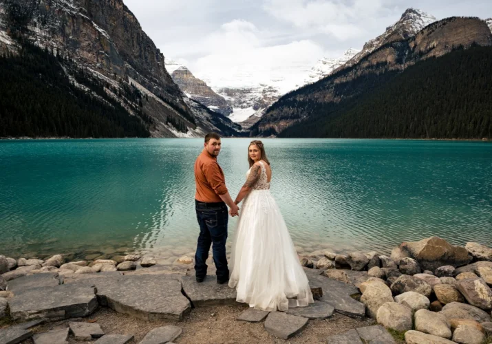 Newlyweds surprised by Calgary Wedding Photographer while adoring the beautiful, turquoise Lake Louise in Banff.