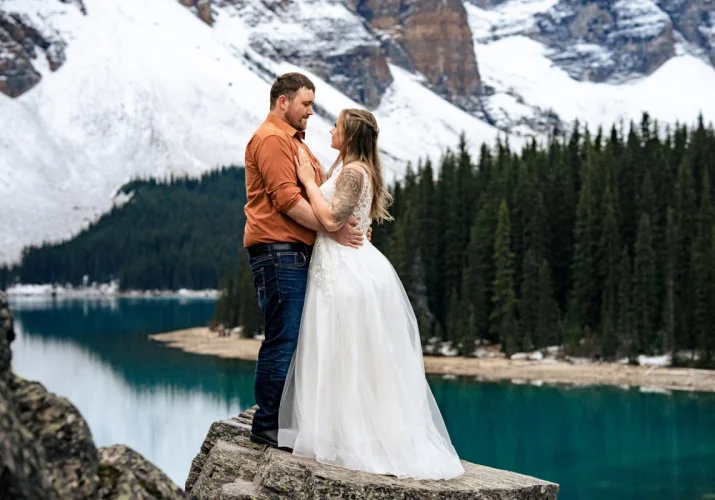 Handsome newlyweds hug each other at Moraine Lake.