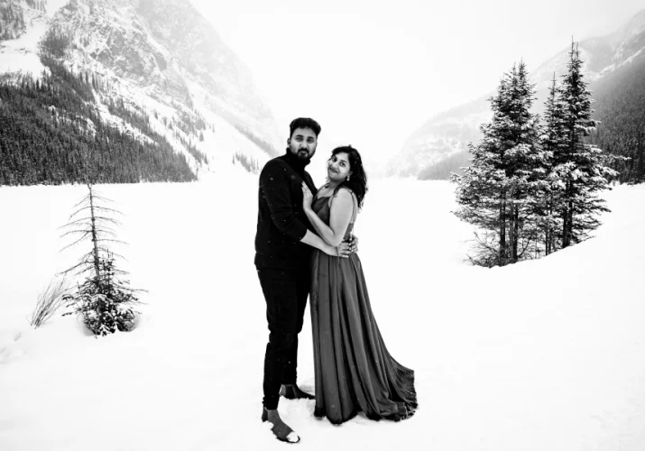 black and white photograph of couple in love. They look at the Calgary Wedding Photographer's camera and smile.