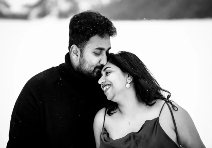 Men kisses his wife's forehead.