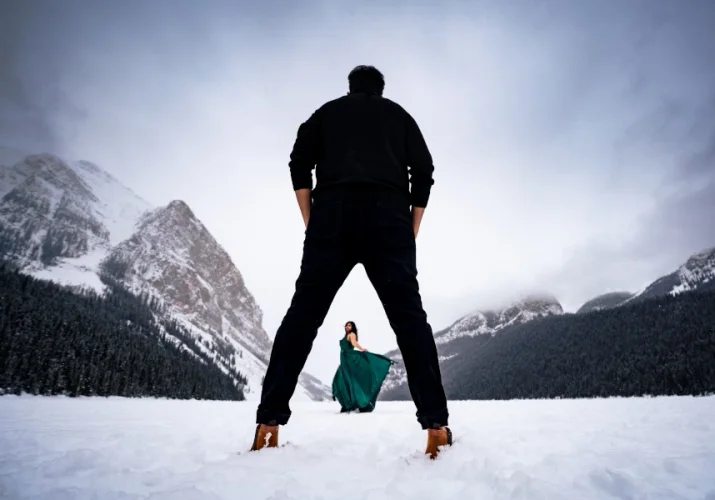 Gentlemen admire his wife dancing for him at t he frozen Lake Louise in Banff National Park.