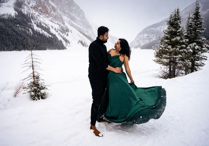 Indian, good dresses couple hug each other and look deeply into each other eyes. It is winter in the Canadian Rocky Mountains.