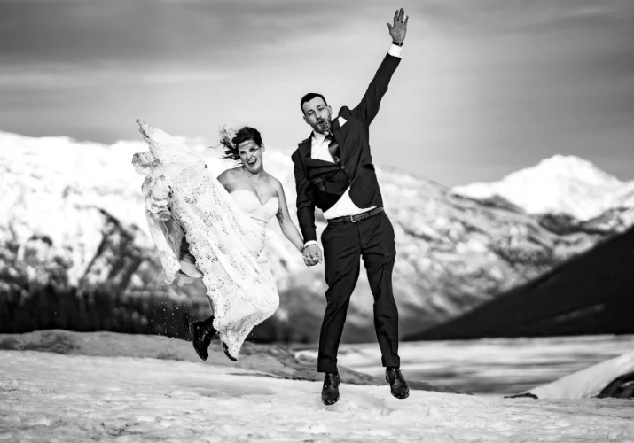 Newlyweds jump high. They have fun.