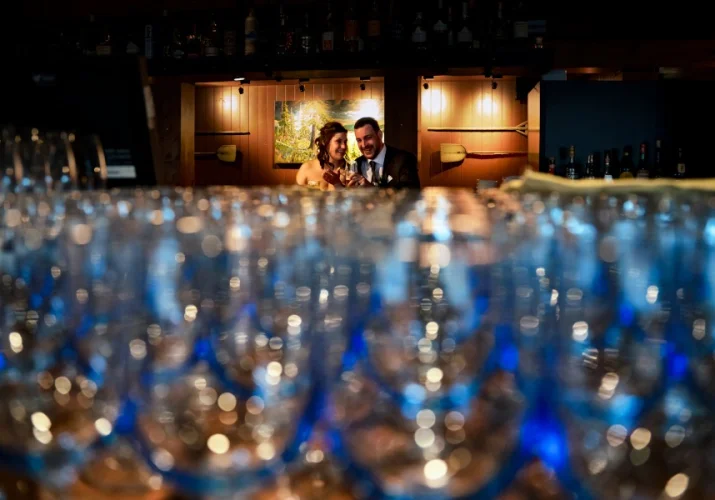 Wedding Reception. Bride and groom sit at the bar and talk.