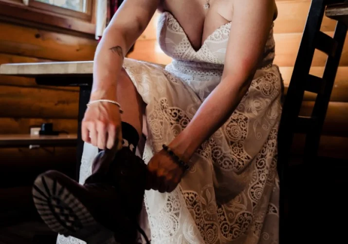 The bride puts hiking buts on before winter Banff elopement.