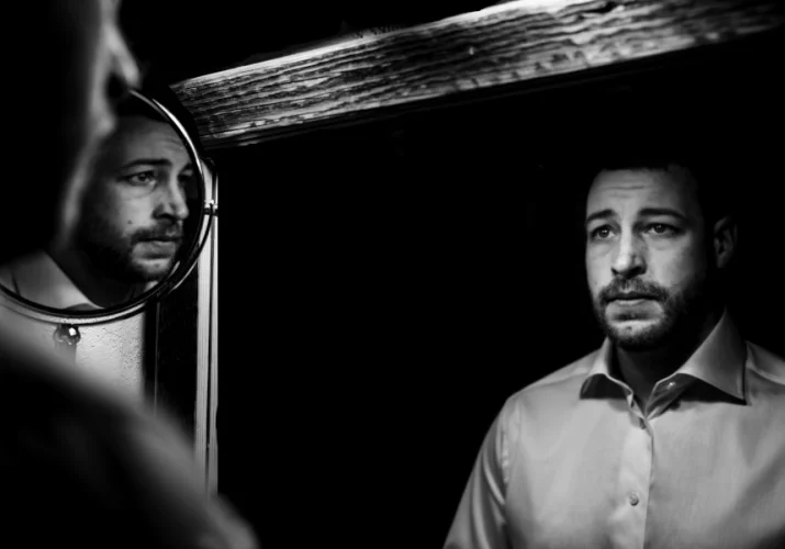 creative photography of the groom. Mirror reflections in black and white.