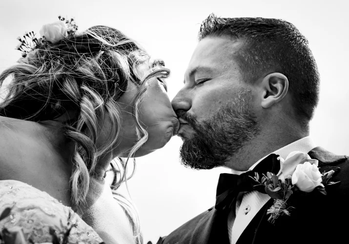 Bride;s and groom's first kiss in black and white captured by Calgary Wedding Photographers.