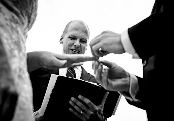 Groom puts a wedding ring on the bride's finger.
