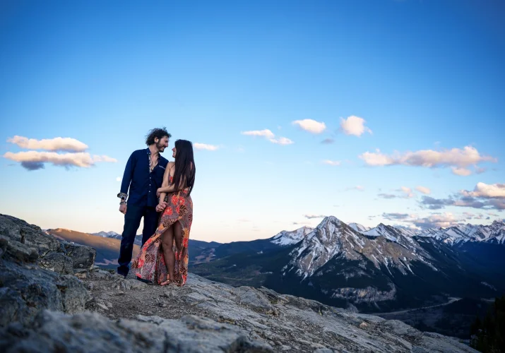 Artistic portrait of engaged couple against a background of sky.