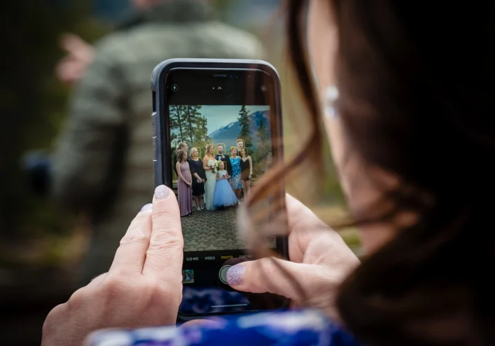 Lady takes a picture of their family after wedding ceremony in the Canadian Rockies.