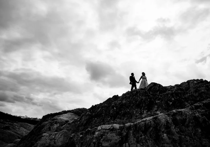 Black and white photograph of newlyweds walking on the top on the mountains in the Canadian Rockies,