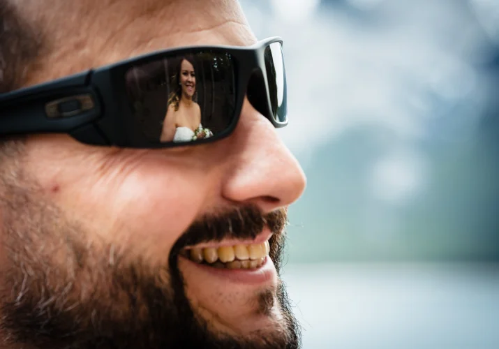 bride's reflection in the groom's sunglasses