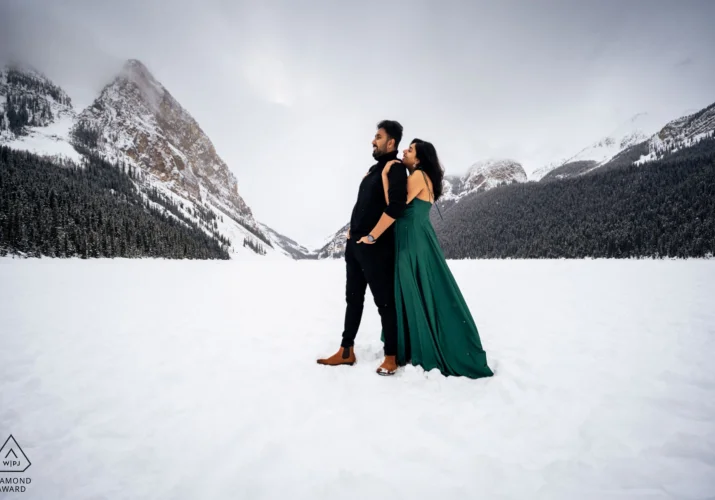 Couple in love in a hug at the frozen Lake Louise in Banff.