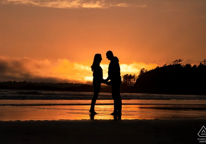A couple looking deeply into each others eyes during amazing sunset.