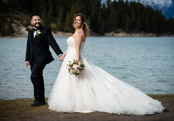 Bride and groom by the Minnewanka Lake in Banff.