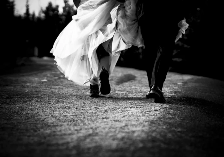 bride's and groom walk. she wears hiking boots.