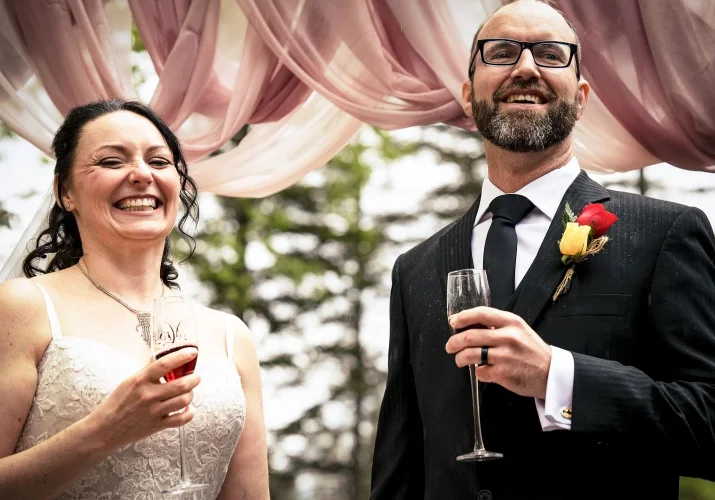 Newlyweds drink champagne and smile after wedding ceremony