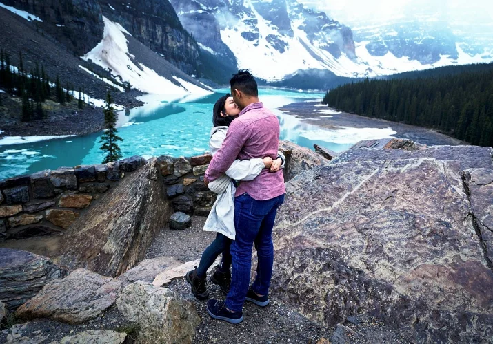 a couple share a kiss after proposal.