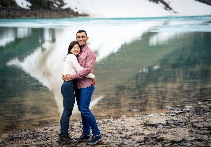 Young and handsome couple hug each other and look at the Banff Wedding Photographer's camera.