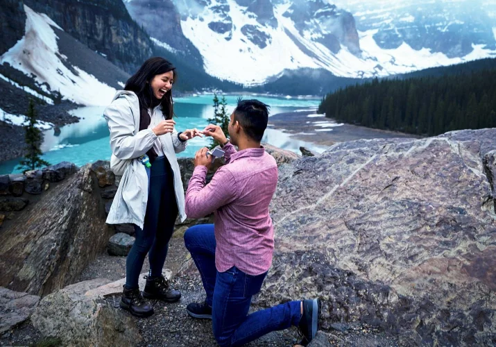 Engagement in Banff. Man puts an engagement ring on his fiancee finger.