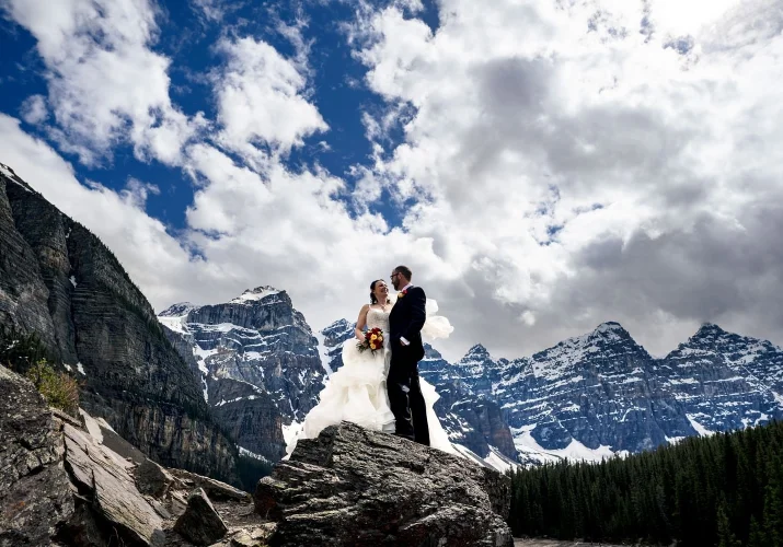 Stunning wedding portrait in the mountains captured by Banff Wedding Photographers. Newlyweds look at each other ans smile.