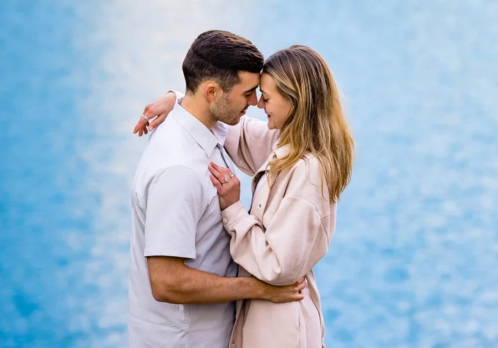 Couple in love touches their heads and hug during their engagement session inn Banff