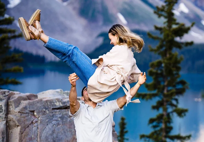 Man tossing his fiancee during engagement session in Banff.