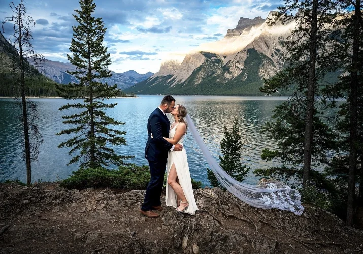 bride and groom hug each other against the stunning view of the lake in Banff