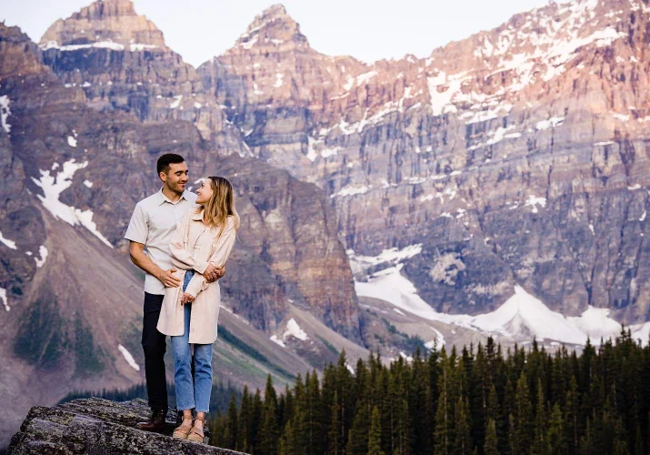 Post proposal portrait of hugging couple with the Canadian Rockies skyline.