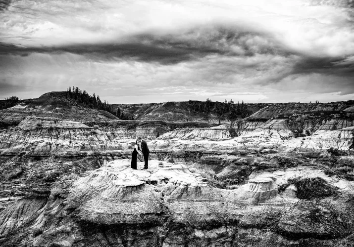 Unique photograph in black and white of coupe kissing in Drumheller Horseshoe Canyon.