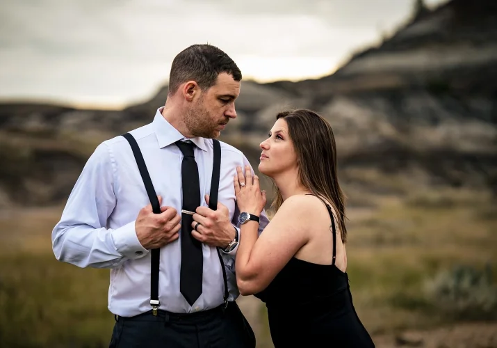 Elegant dressed married couple looking at each other. Lady rest her arm on her husband's shoulder.