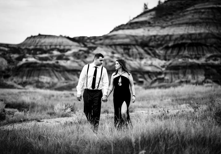 Married couple walk at the Horseshoe Canyon holding their hands and look at each other.