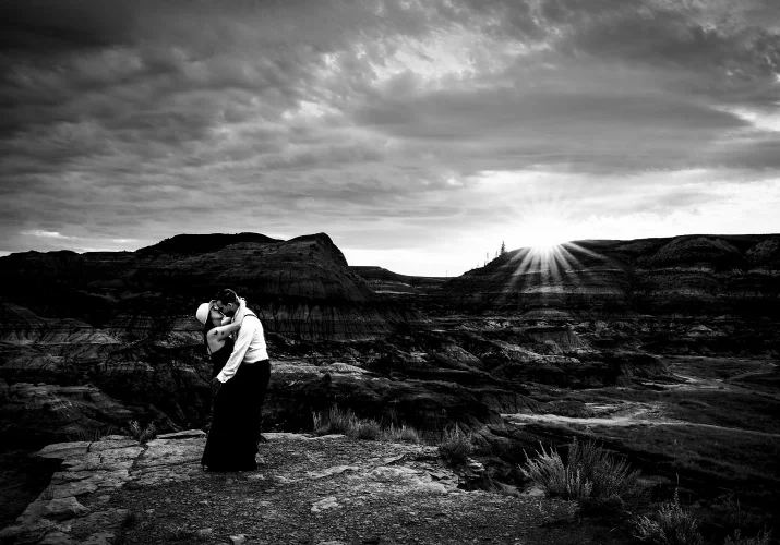 Amazing photograph of hugging couple against Horseshoe Canyon in Drumheller Alberta.