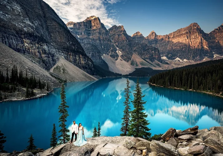 Amazing turquoise Moraine Lake and tiny engaged people surrounded by the Canadian Rockies.