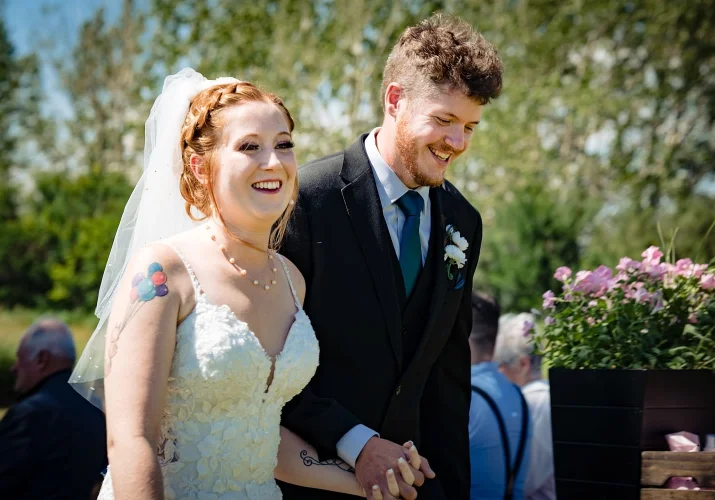 Bride and groom hold their hands white