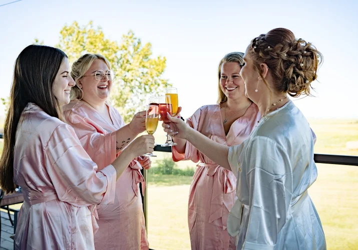 Bridal party clink the glasses during getting ready time at countryside wedding in Calgary.