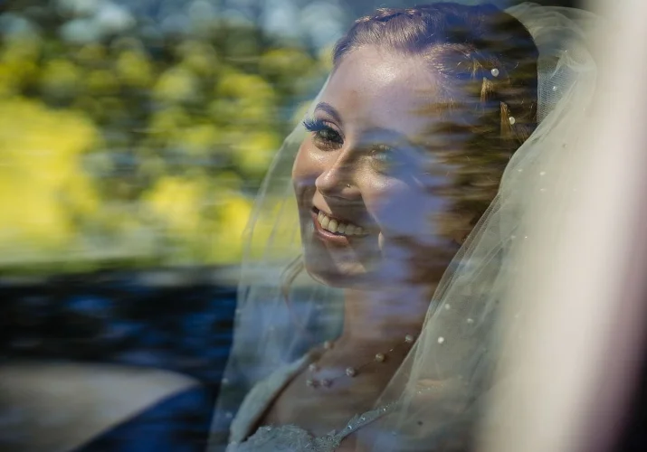 Bride's portrait through the car's window.