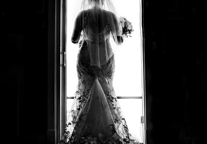 Bride's photograph from the back leaving the house.