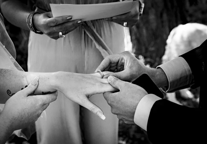 Broom puts the ring on the bride's finger.