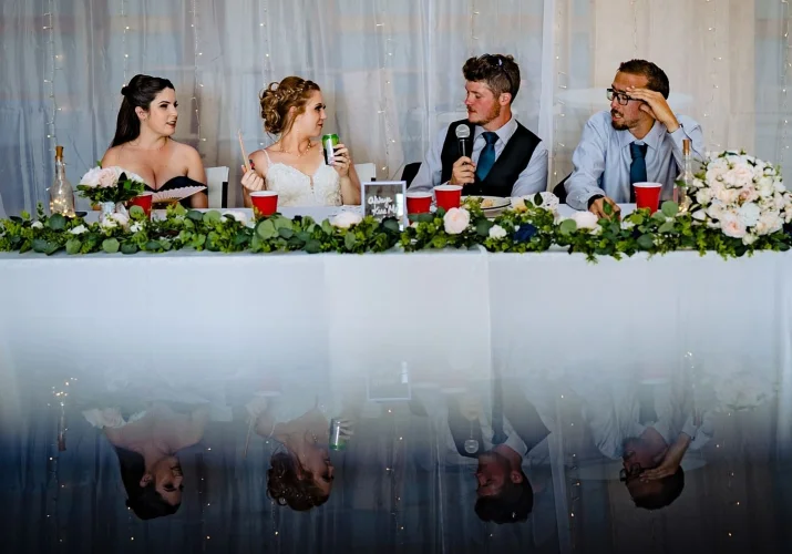 Grooms speak with unique reflection during countryside wedding in Calgary.